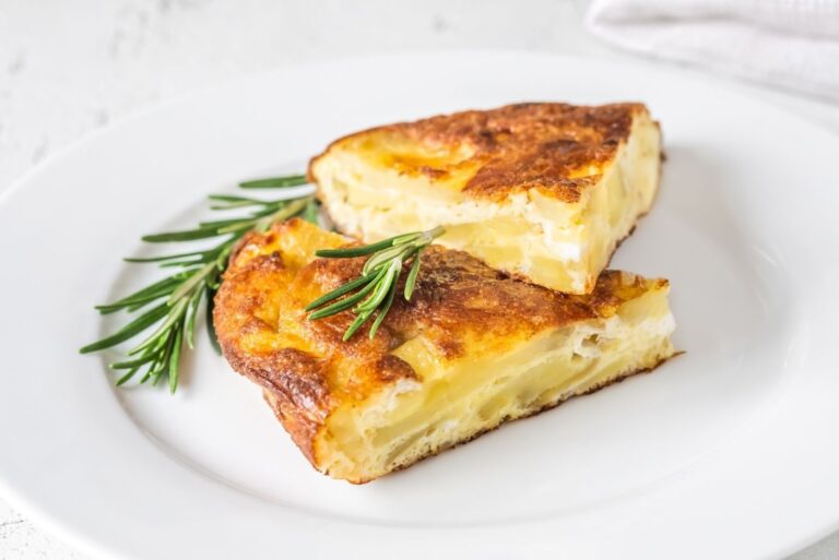 Due fette di frittata di lupini e cipolla su un piatto con alcuni rametti di rosmarino